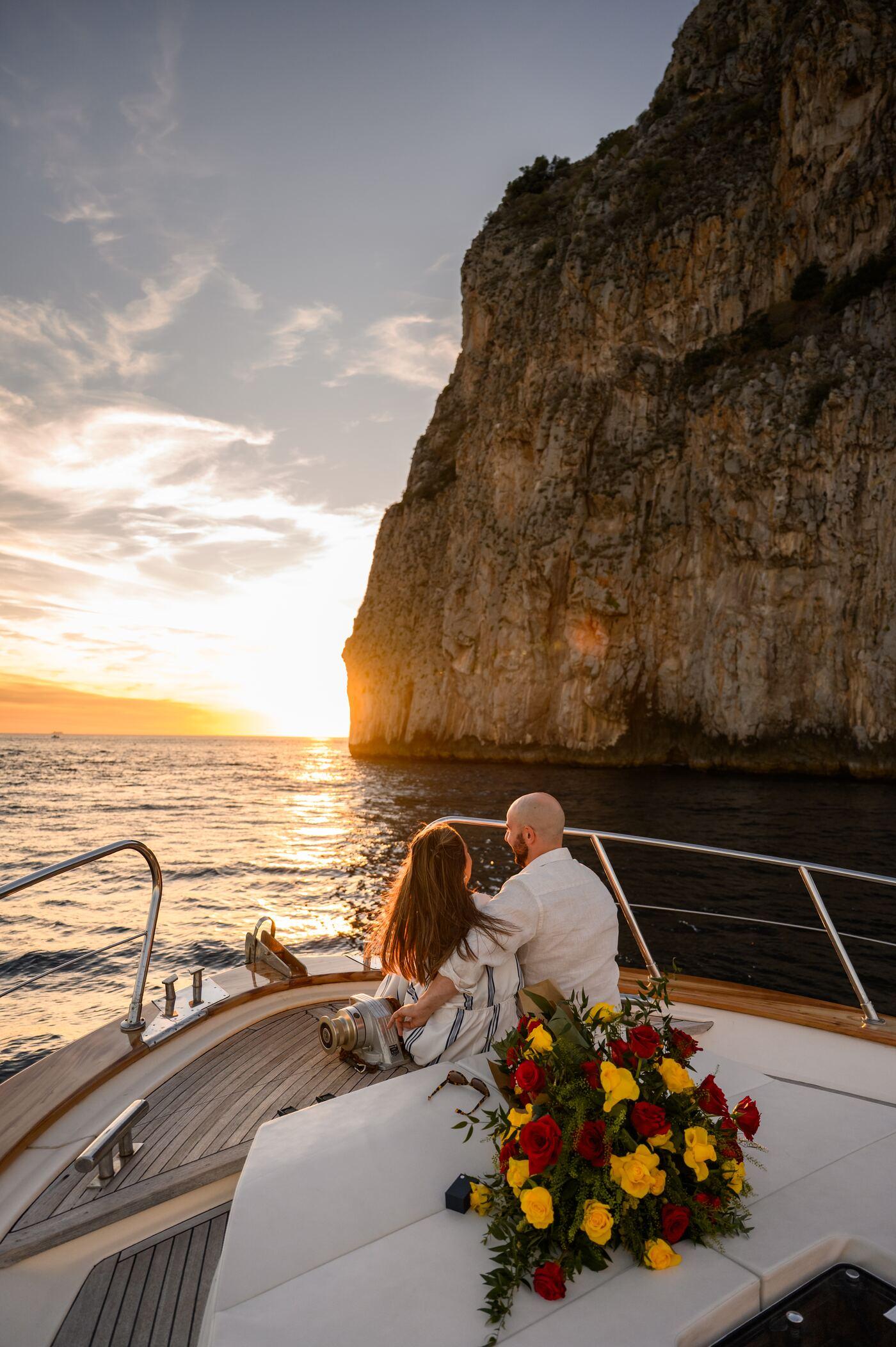 Couple watching the sun set beside Capri's cliffs